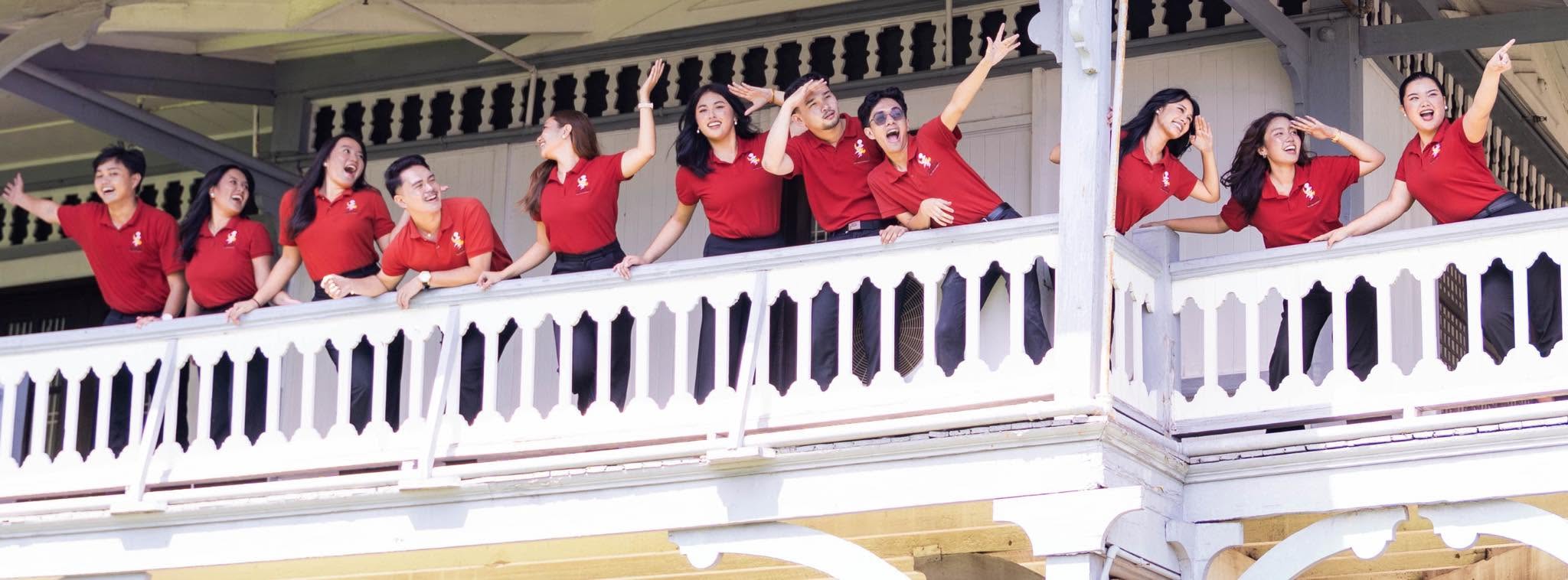 Silliman University Campus Ambassadors welcoming visitors from a campus balcony